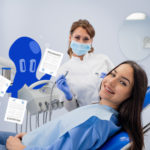 blije vrouw in een tandartsstoel en doctopus die haar de verzekeringspolis laat zien